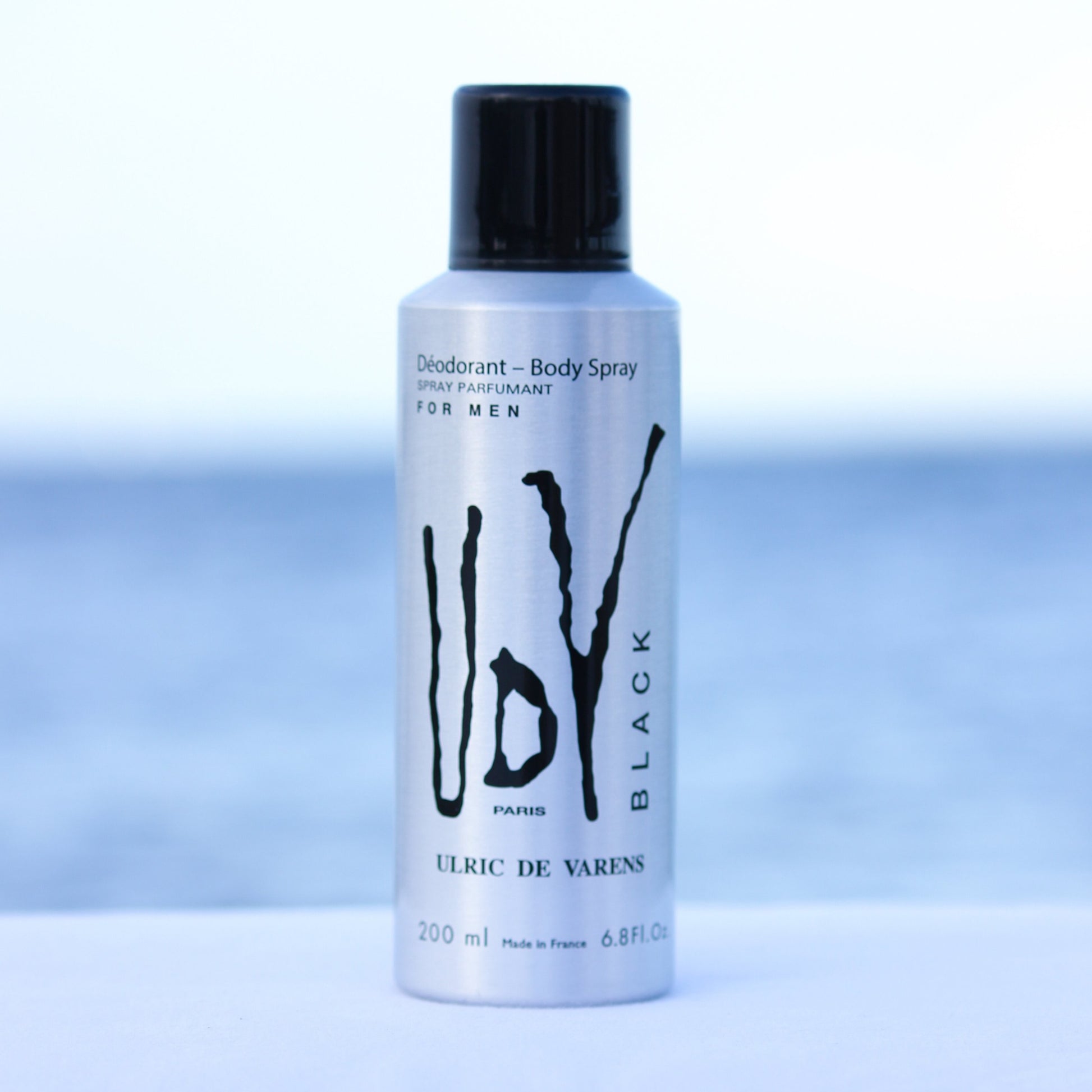 Ulric De Varens UDV Black men's perfume scented deodorant 6.4 oz in front of beach