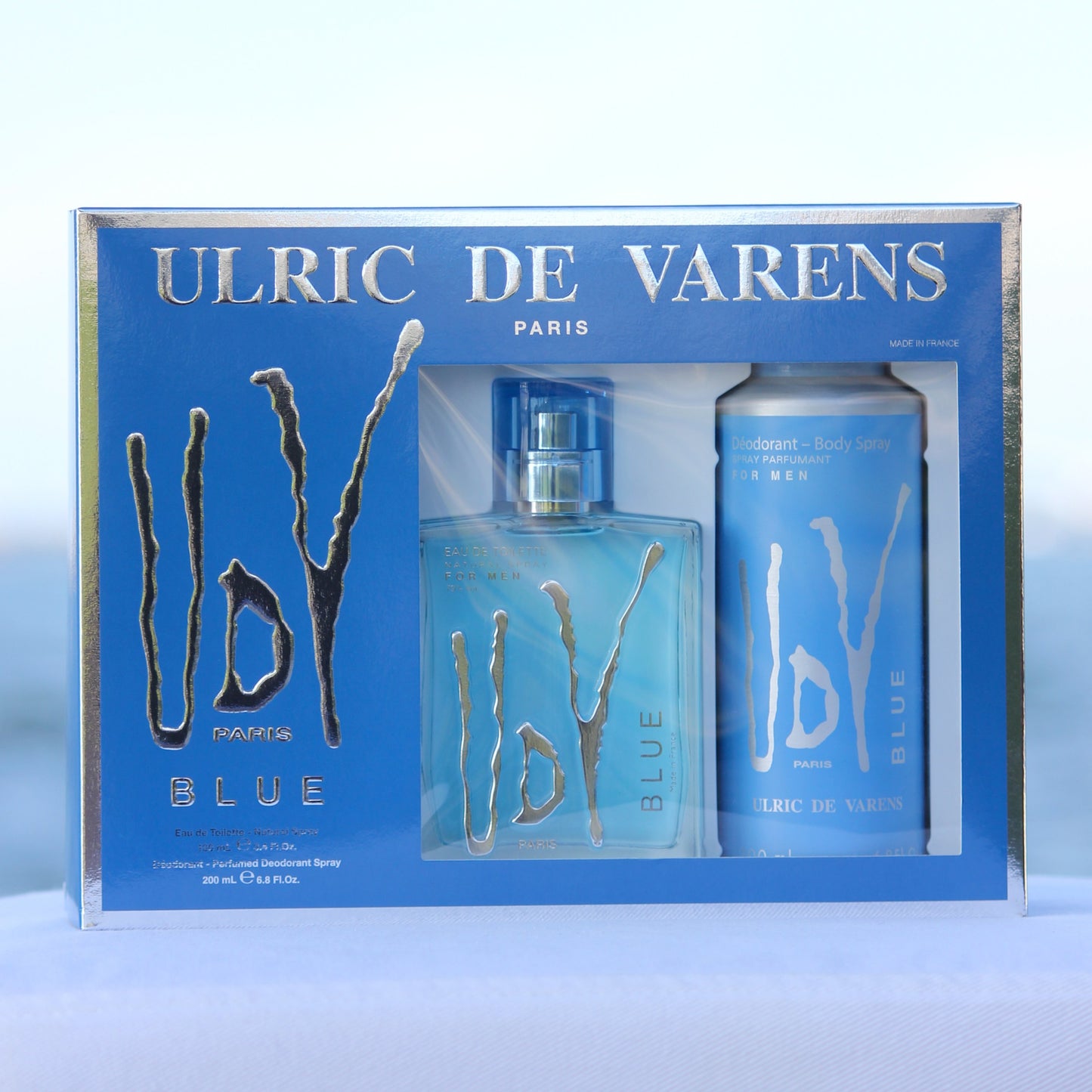 Ulric De Varens UDV Blue Gift Set men's perfume 3.4 EDT and deodorant 6.8 oz in front of beach